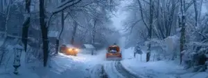 a snow plow clearing a path through a snow-covered street in zelienople during a blizzard.