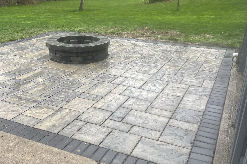 Backyard paver patio with a maintained green lawn behind it, built by Daily Landscaping in Western Pennsylvania