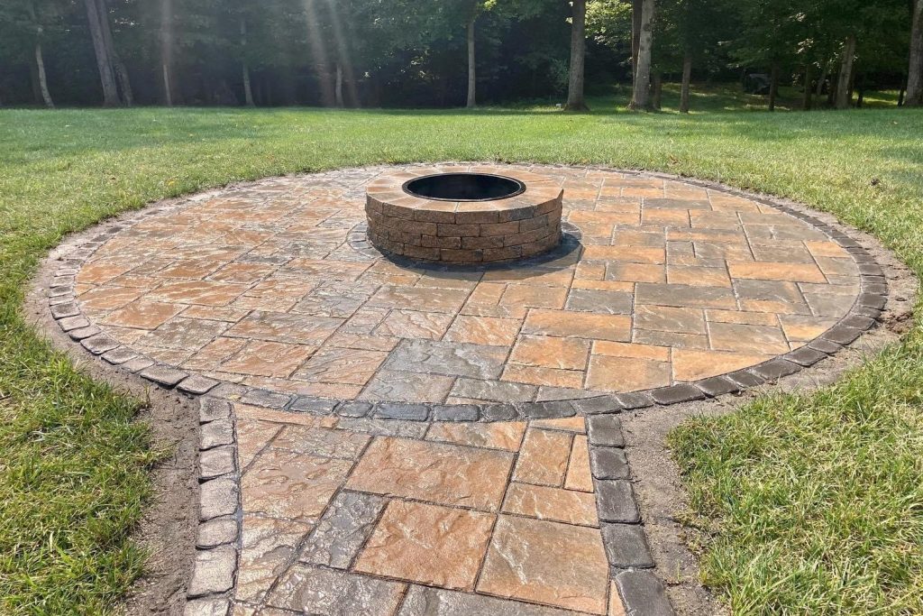 Circular flagstone patio with a round stone fire pit and connecting walkway, built by Daily Landscaping in Western Pennsylvania