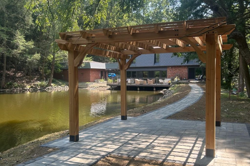 Lakeside patio with a pergola and stone walkway built by Daily Landscaping in Sarver, PA