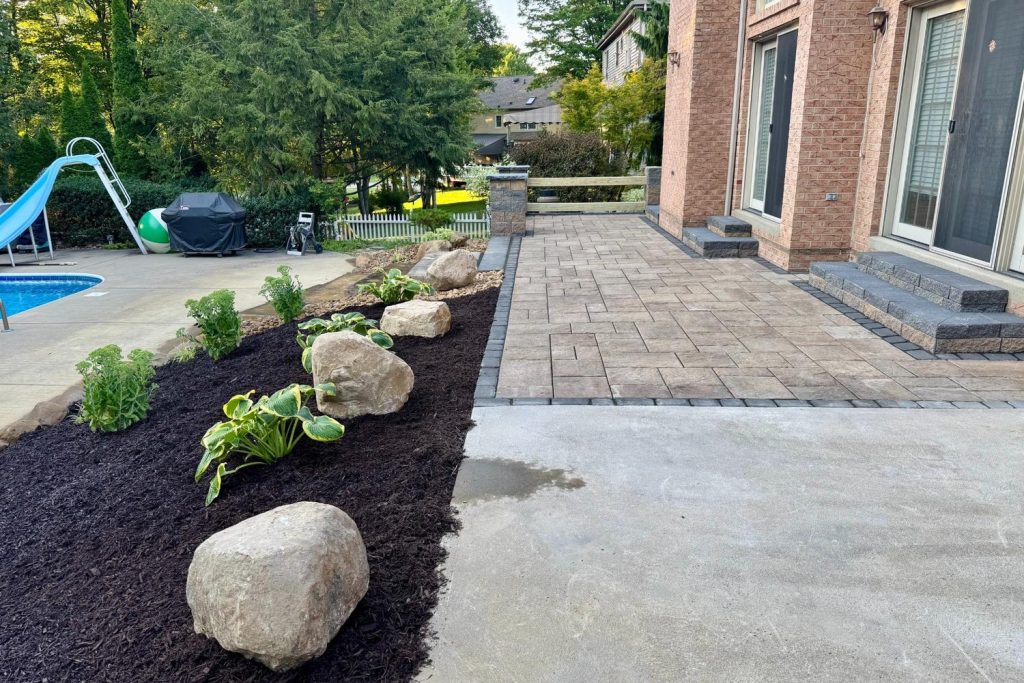 Raised paver patio with a staircase down to the pool, built by Daily Landscaping in Cranberry Township, PA