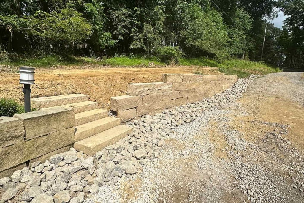 Sandstone retaining wall alongside a driveway, built by Daily Landscaping in Wexford, PA
