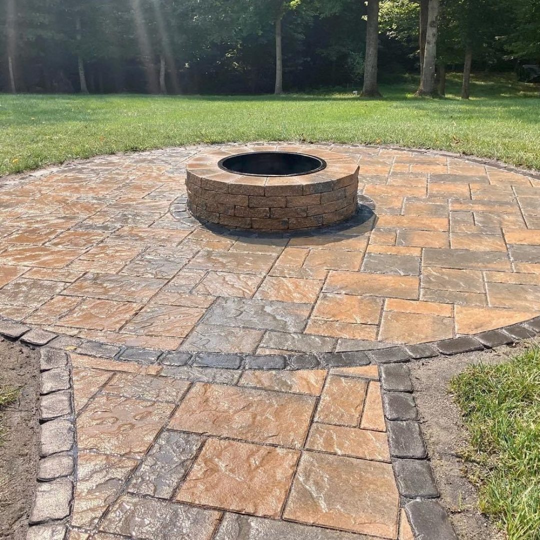 Circular flagstone patio with a round stone fire pit and connecting walkway, built by Daily Landscaping in Western Pennsylvania