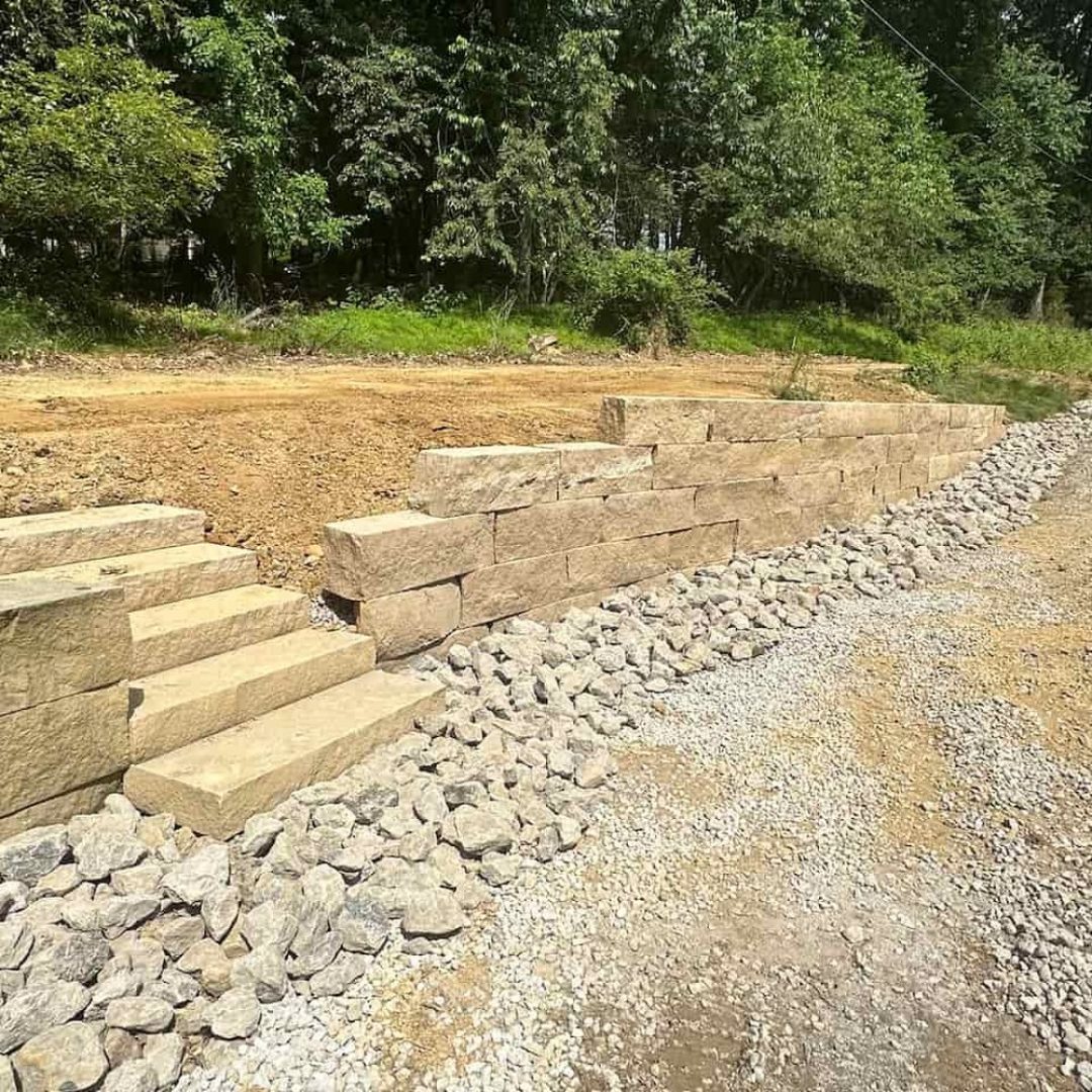 Sandstone retaining wall alongside a driveway, built by Daily Landscaping in Wexford, PA